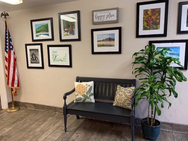 A cozy waiting area with wall art and a bench.