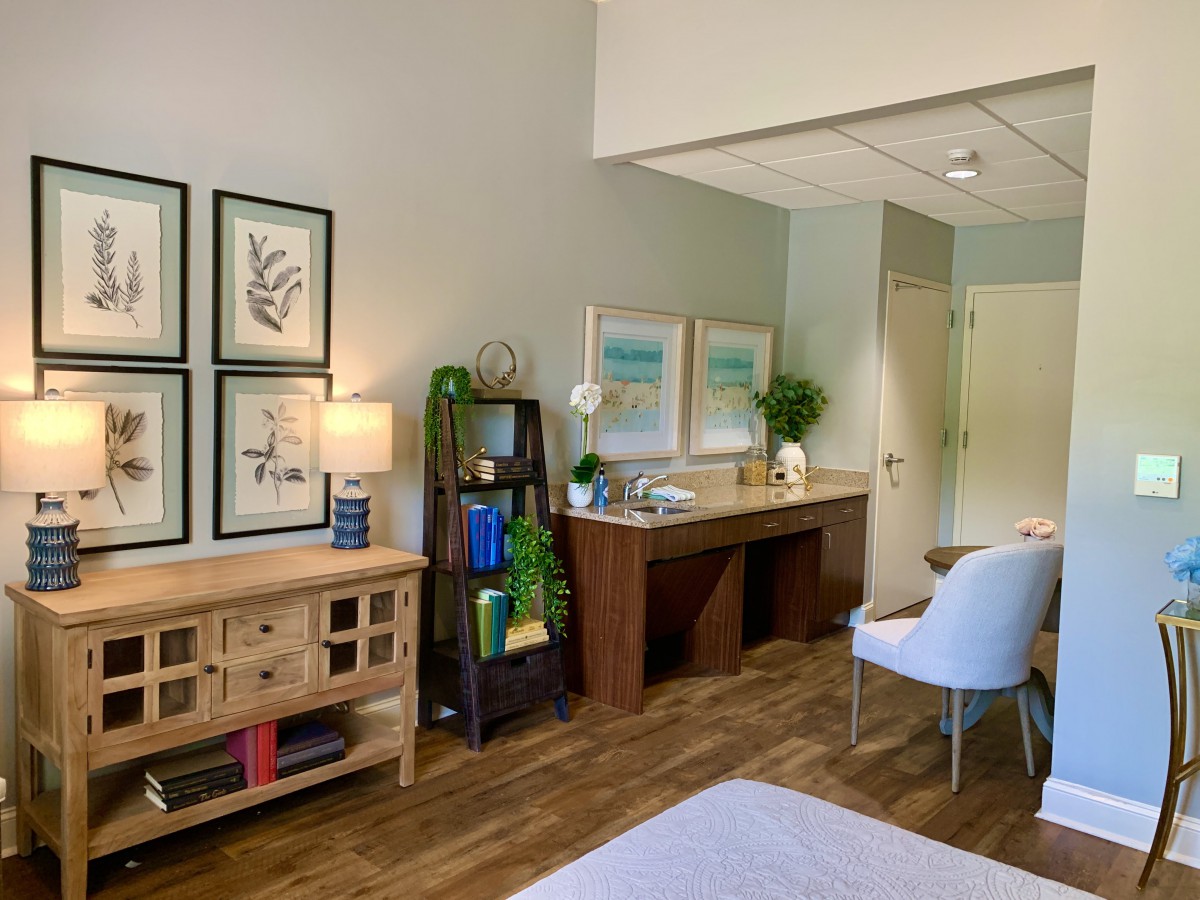 A modern bedroom with stylish decor and wooden flooring.