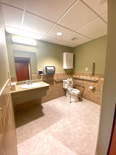 A well-maintained bathroom featuring a toilet, sink, and hand dryer.