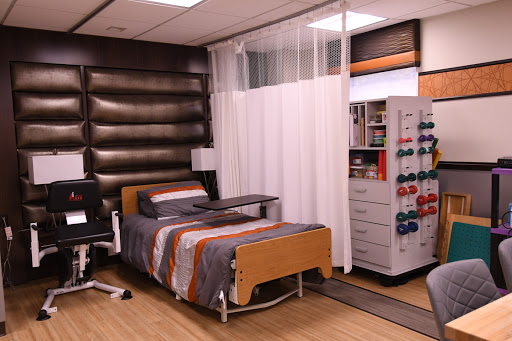 A well-equipped hospital room featuring a patient bed, curtain for privacy, and organized storage.