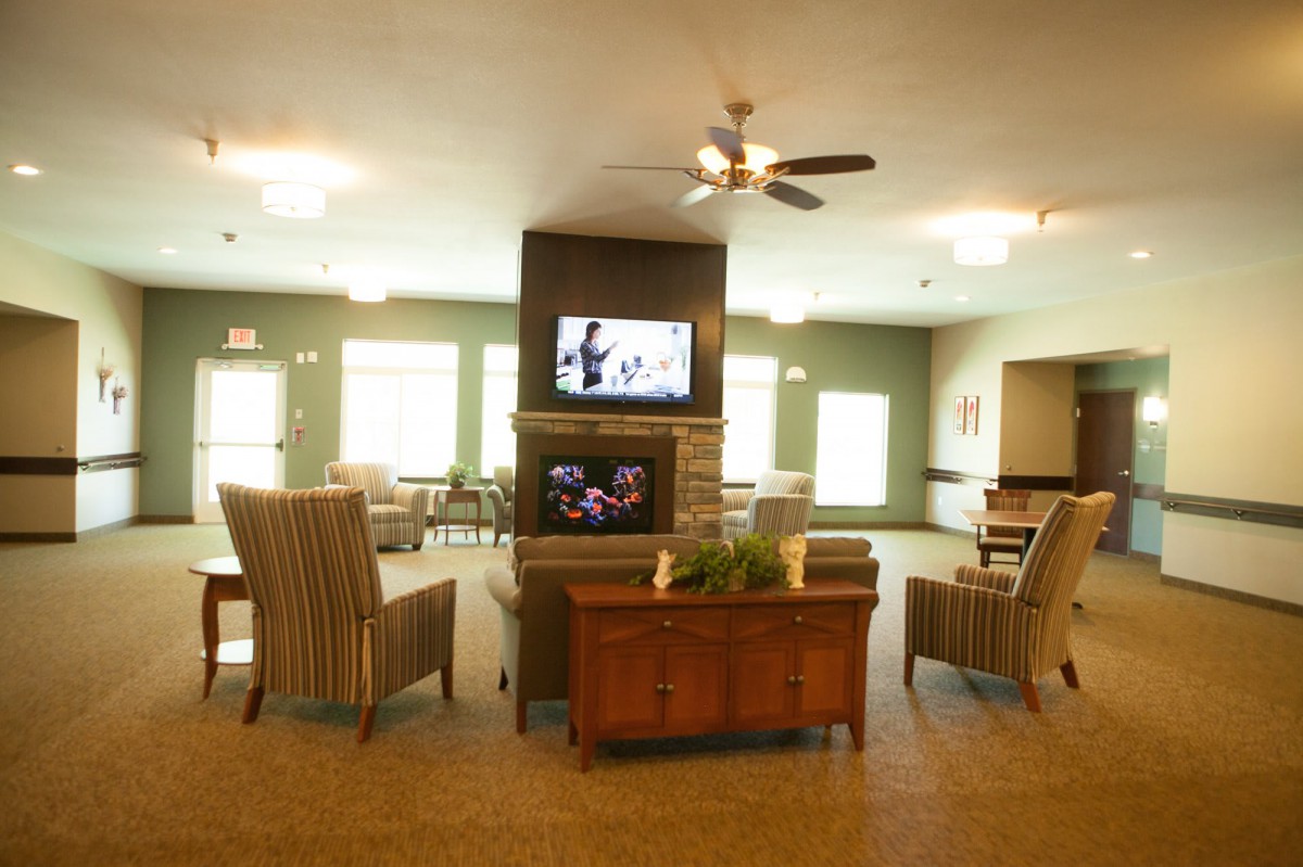 A modern living room with comfortable seating and a television mounted on a central wall.