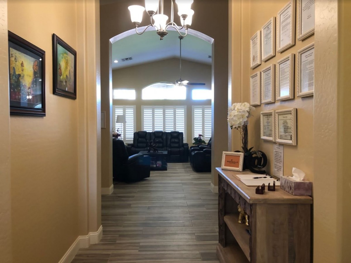 A cozy hallway leading to a living room, adorned with certificates and a small table.