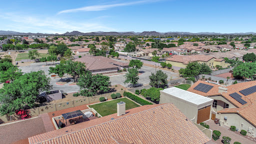 A bright, sunny aerial view of a suburban neighborhood showcasing houses and lush greenery.