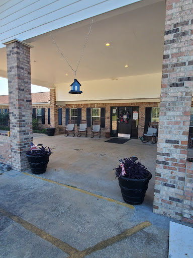 A welcoming entrance featuring brick columns, potted plants, and decorative lighting.