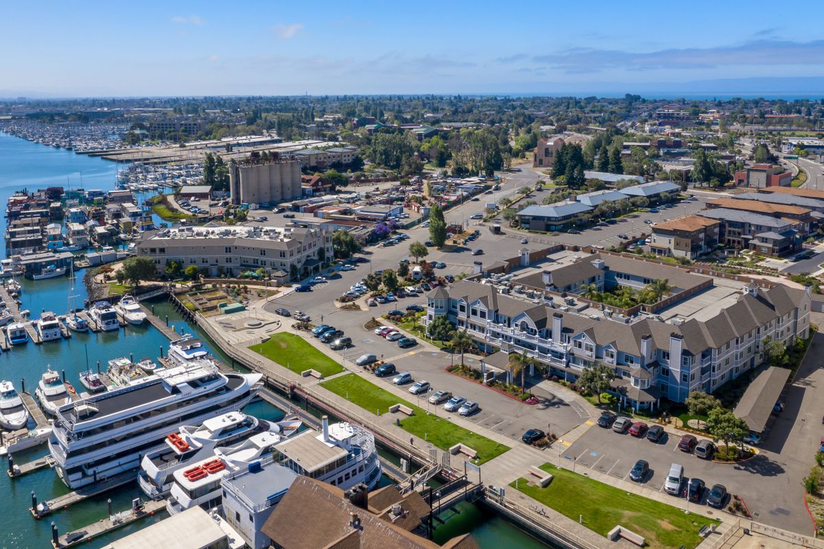 Aerial view of a coastal town with a marina and various buildings.