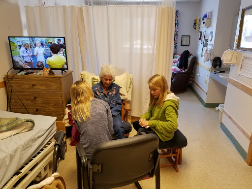 Family members spending quality time with an elderly woman in a care home.