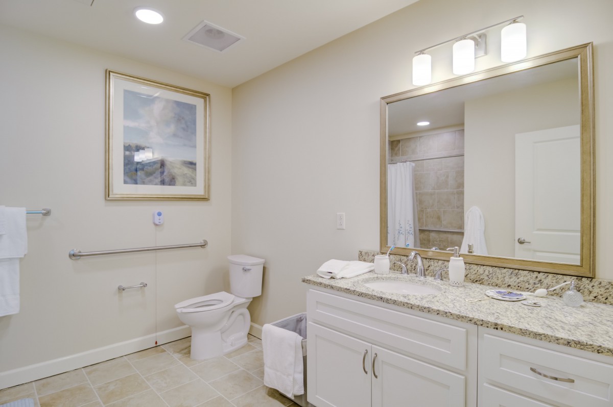 A modern and clean bathroom interior featuring a sink, mirror, and toilet.