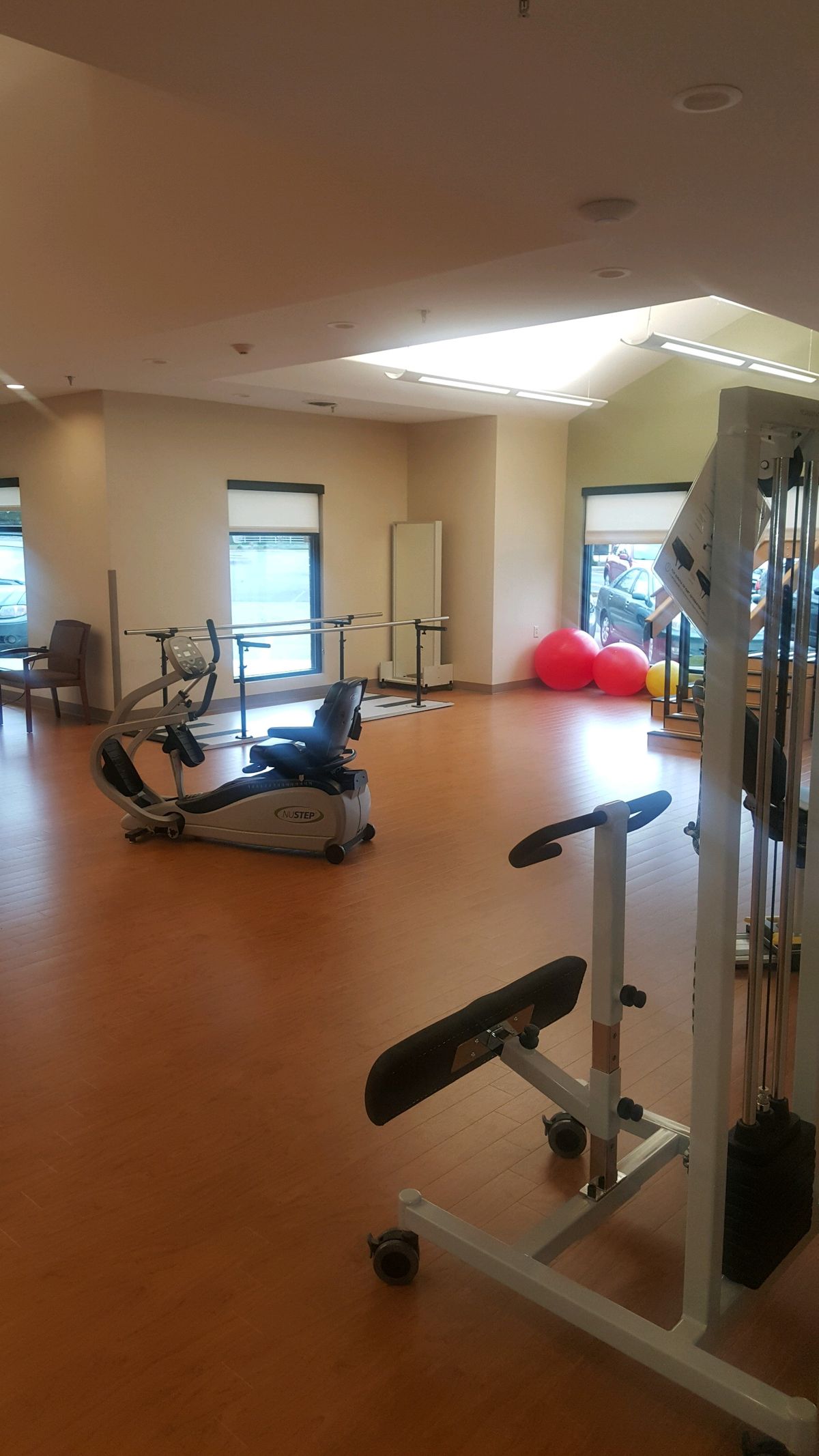 A well-lit gym with various exercise equipment and a spacious workout area.