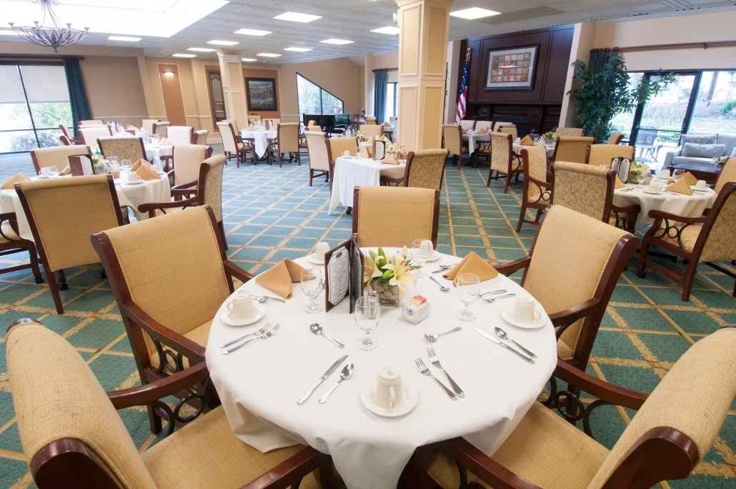 An elegantly set dining table within a spacious restaurant interior.