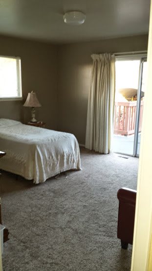 A simple bedroom with a single bed and access to a balcony.