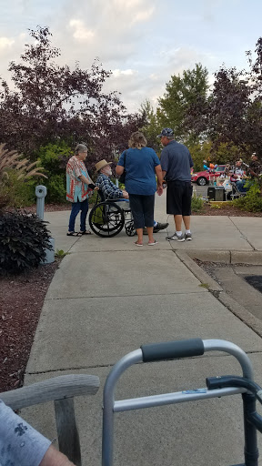 A group of people assisting someone in a wheelchair outdoors.