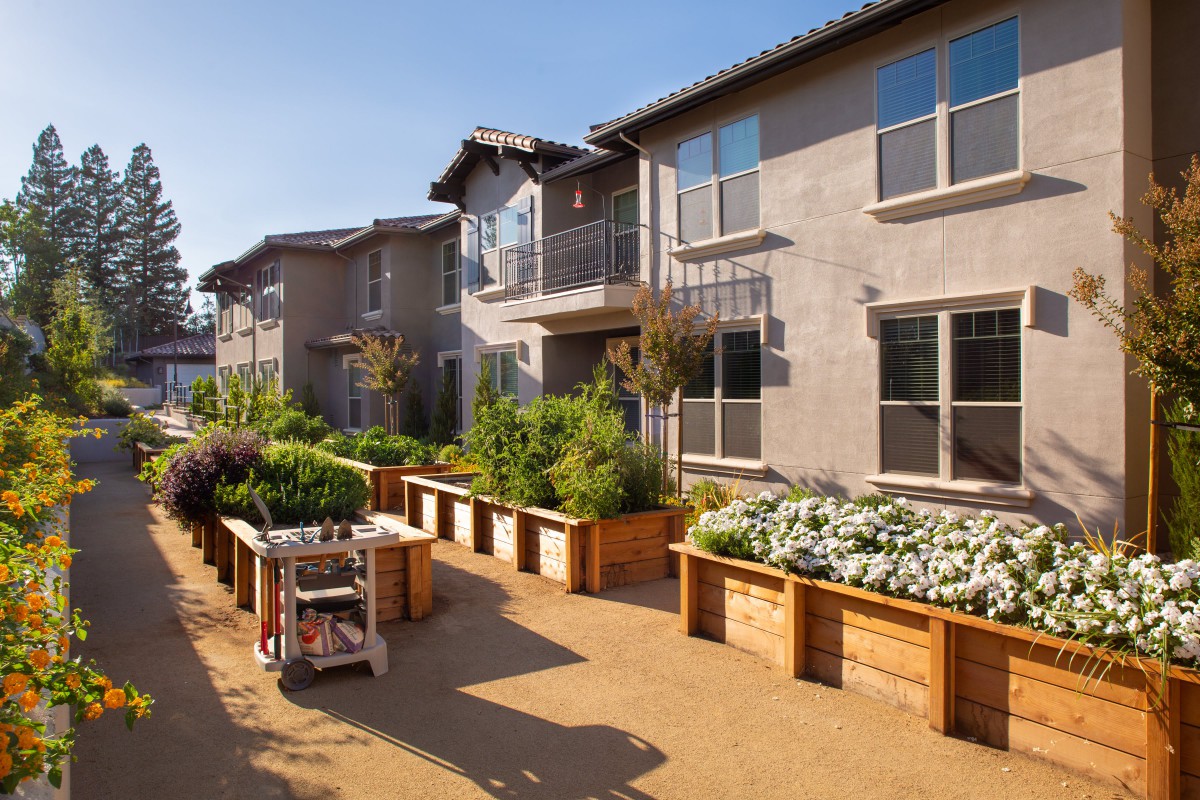 A community garden with raised beds in a residential apartment complex.