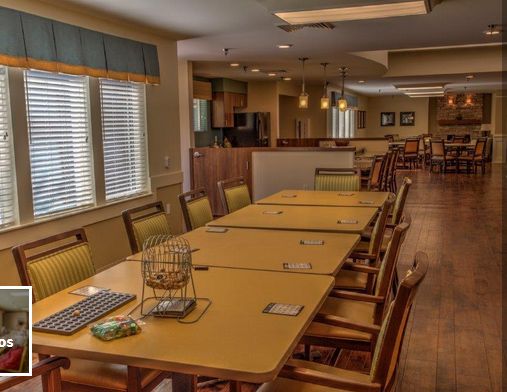 A cozy dining area with a long table and chairs, adjacent to a kitchen space.