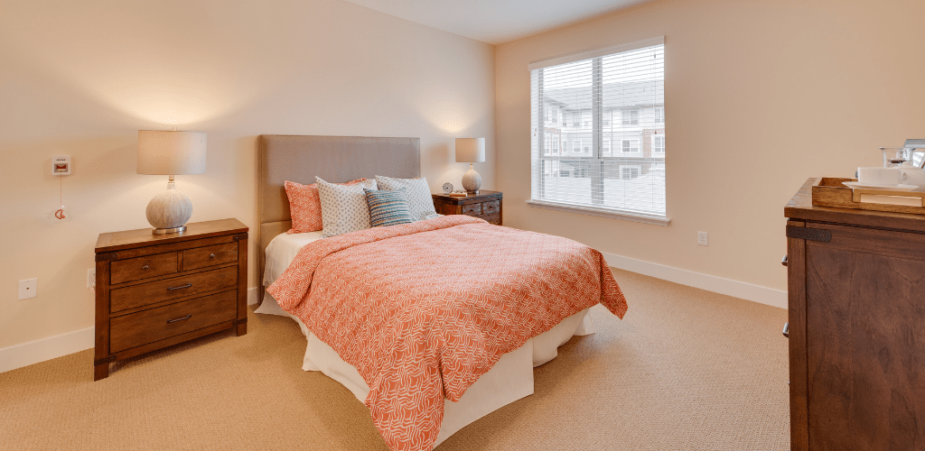 A cozy bedroom with a neatly made bed and natural lighting.