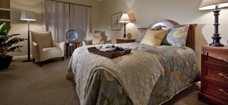 A cozy and elegantly decorated bedroom with a neatly made bed and stylish furnishings.