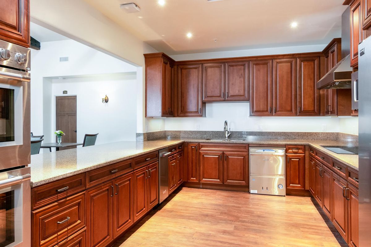 A modern kitchen with wooden cabinets and stainless steel appliances.