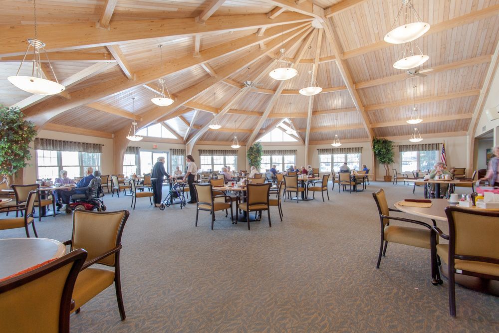 A spacious dining area with a wooden ceiling and natural lighting.