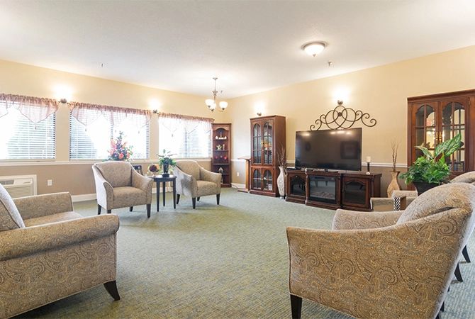 A spacious living room with comfortable seating, a large television, and traditional decor.