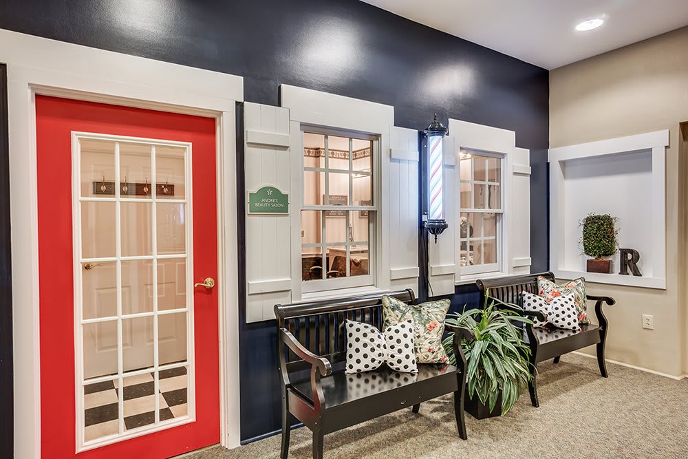 Cozy indoor seating area with benches, plants, and a vibrant red door.