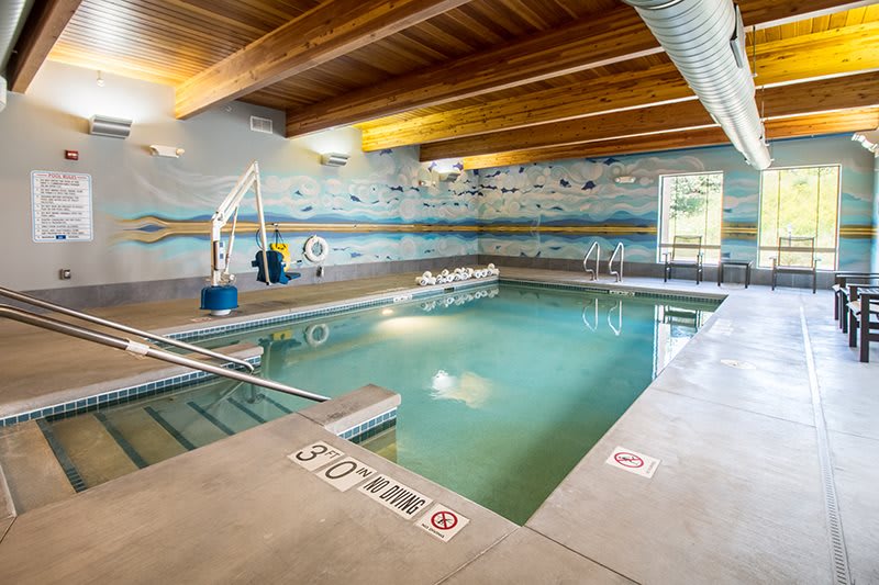 An inviting indoor swimming pool with wooden beams and a relaxed ambiance.