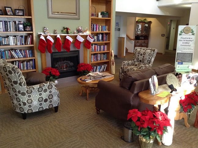 A cozy living room decorated for the holidays with stockings hung on the fireplace and poinsettias adding a festive touch.