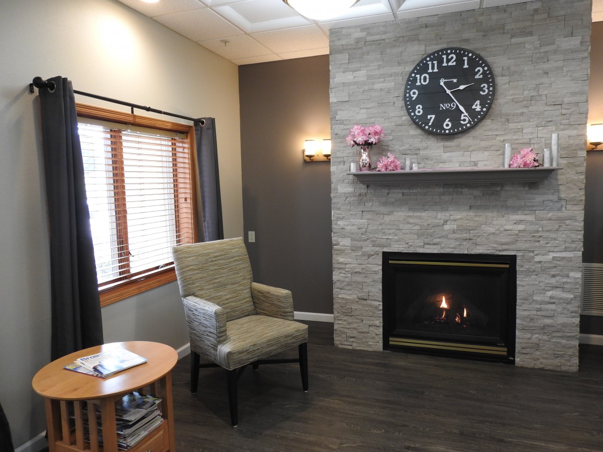 A cozy living room with a modern fireplace and large clock.