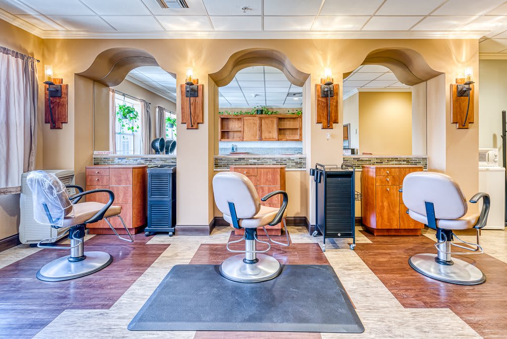 An empty hair salon with chairs and mirrors, ready for clients.