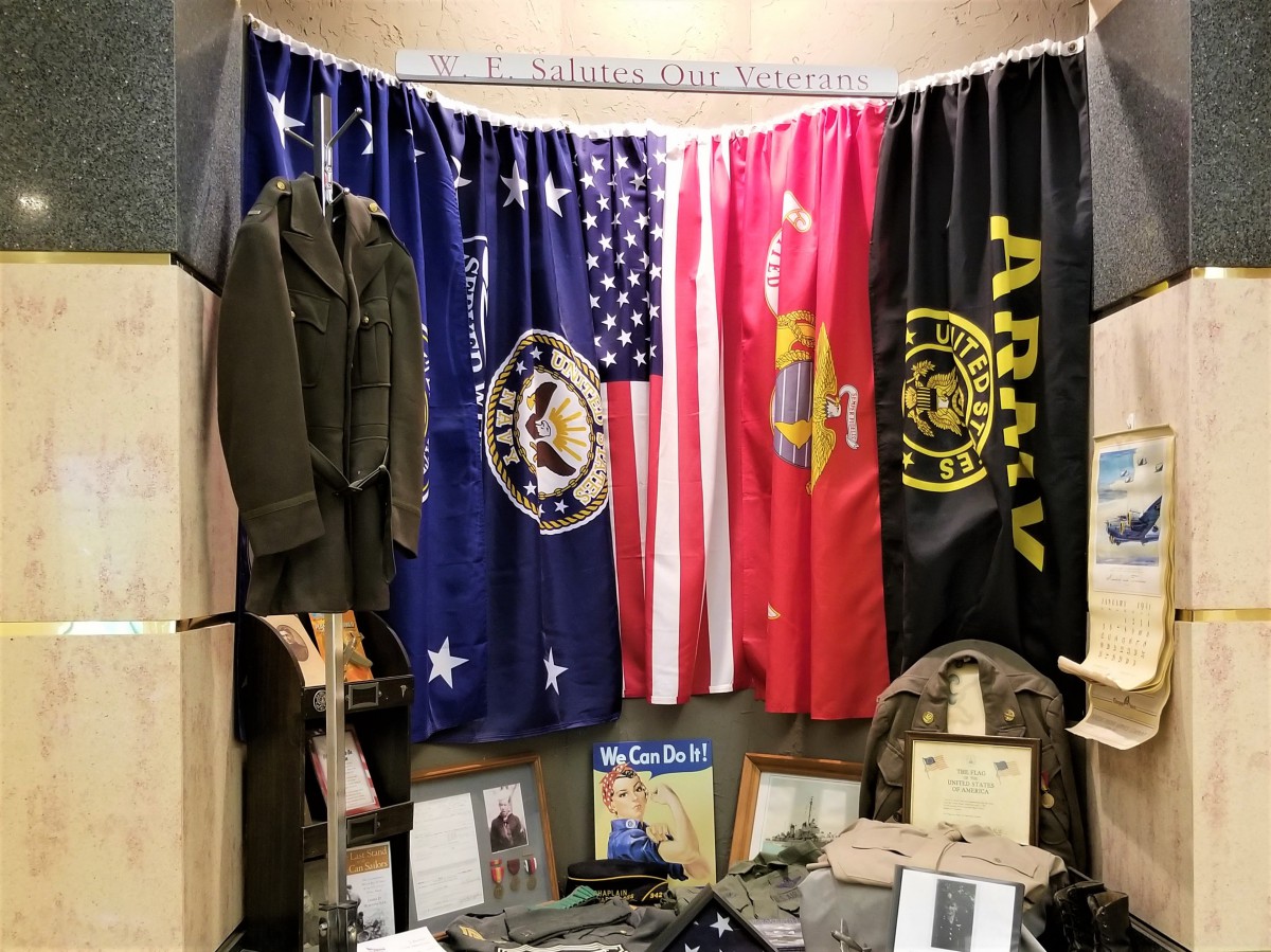 A display featuring military flags, a uniform, and various memorabilia.
