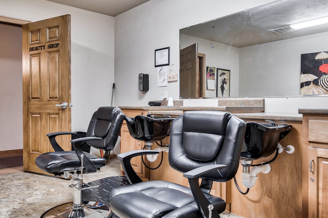An interior view of a barbershop with empty salon chairs and mirrors.