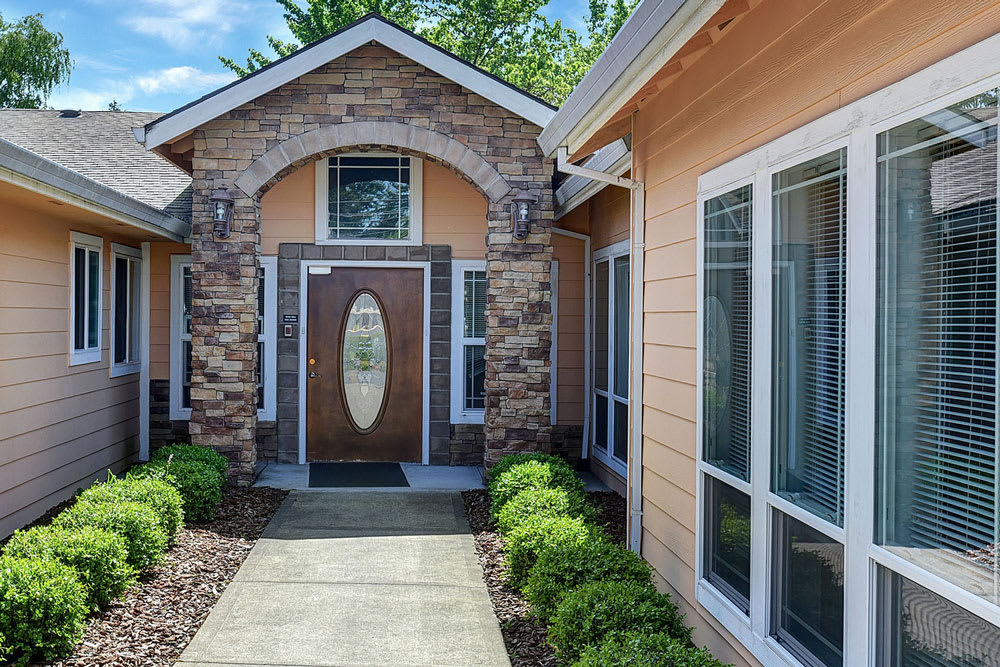A well-maintained house exterior with a stone facade and an inviting front entrance.