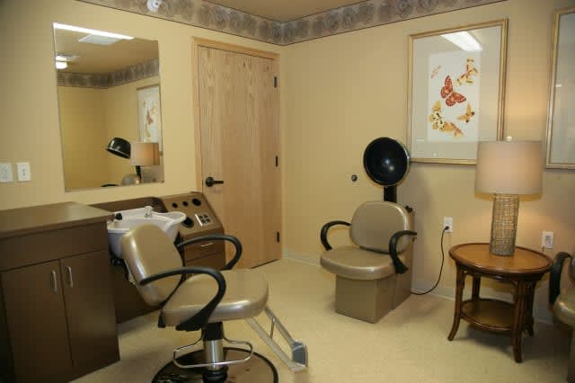A cozy beauty salon with styling chairs, a mirror, and a hair dryer.
