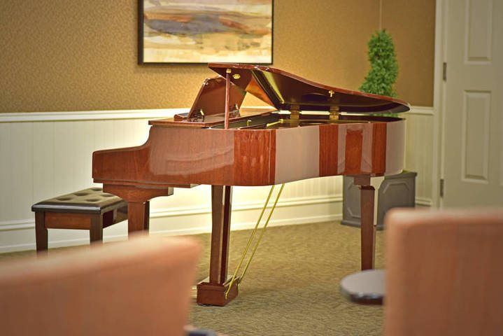 A grand piano sits elegantly in a warmly decorated living room.
