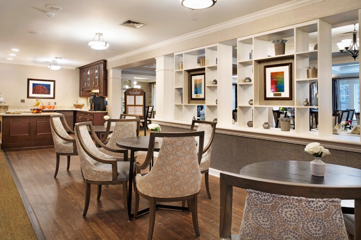 A modern lounge area with elegant seating and decorative artwork on shelves.
