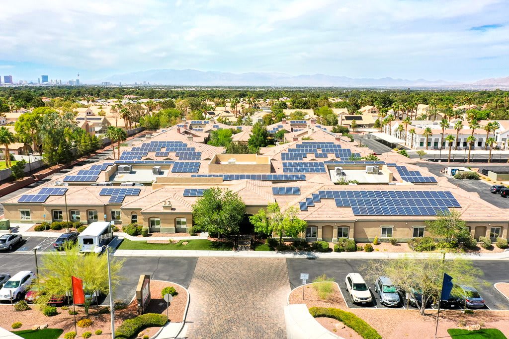 An aerial view of a residential neighborhood with solar panels installed on the rooftops.