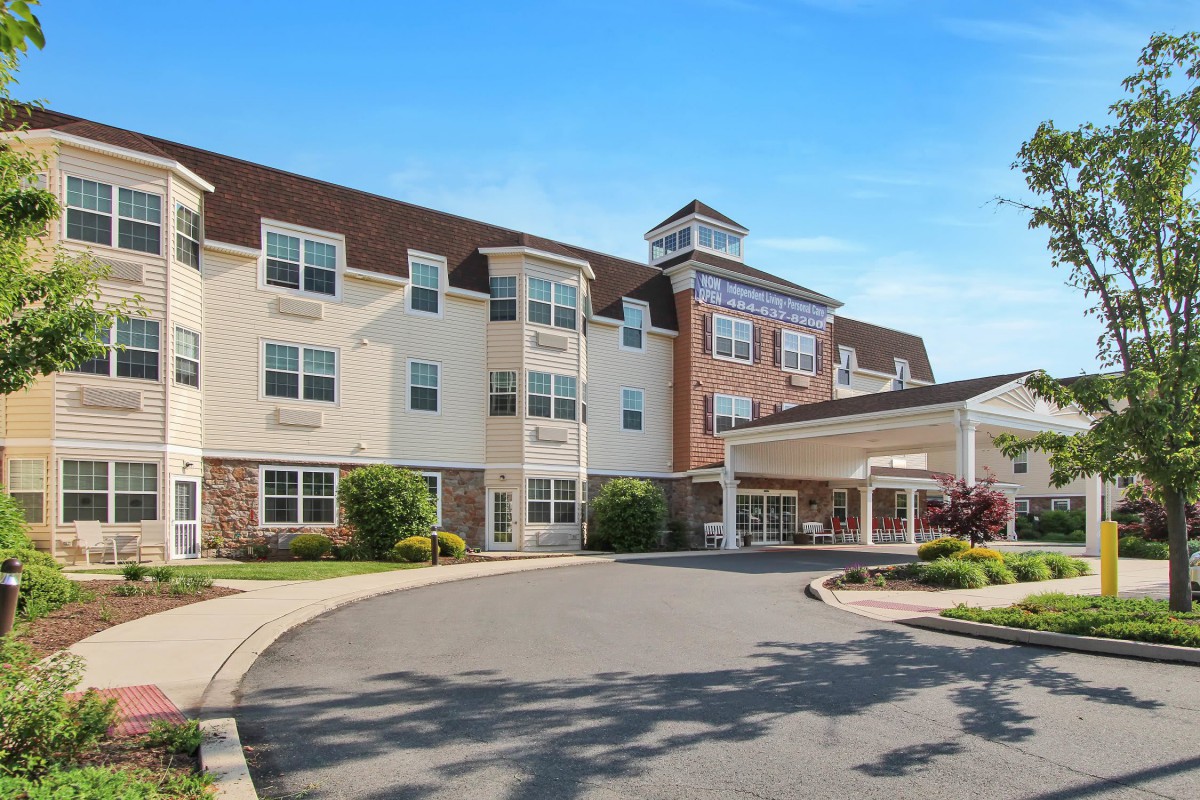 A hotel building with a landscaped entrance and a driveway.