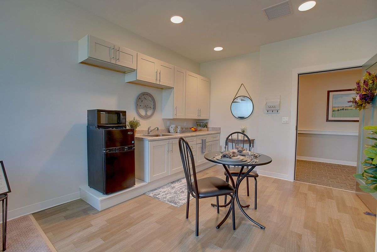 A compact and modern kitchen with a small dining table set.