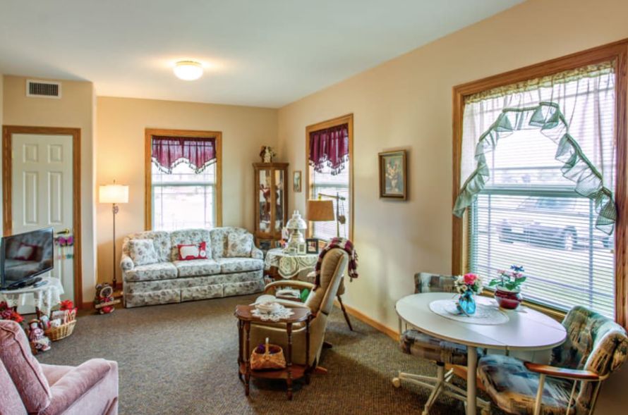 A cozy living room with vintage decor featuring a sofa, armchair, and coffee table.