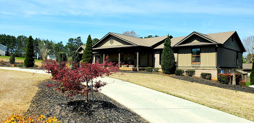 A beautiful single-story house with landscaped gardens and a welcoming front porch.