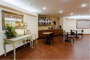 A cozy dining area with wooden flooring, tables, and chairs, decorated with a vintage-style console table and a large star on the wall.
