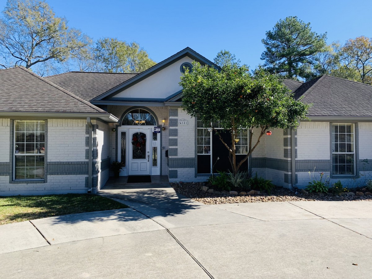 A view of a residential house with a driveway and front yard.
