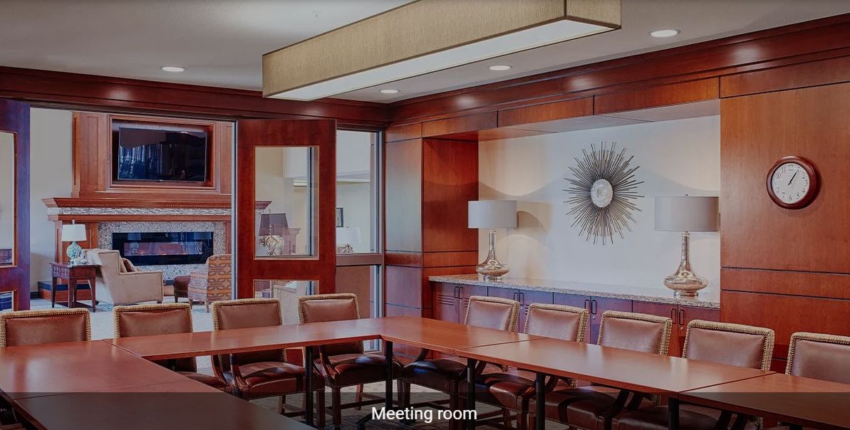 A modern meeting room with a large conference table and chairs.