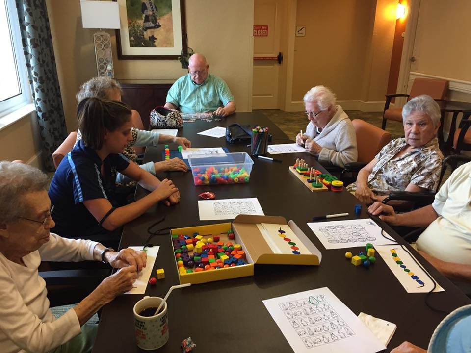 A group of people sitting around a table engaging in puzzle-solving activities.