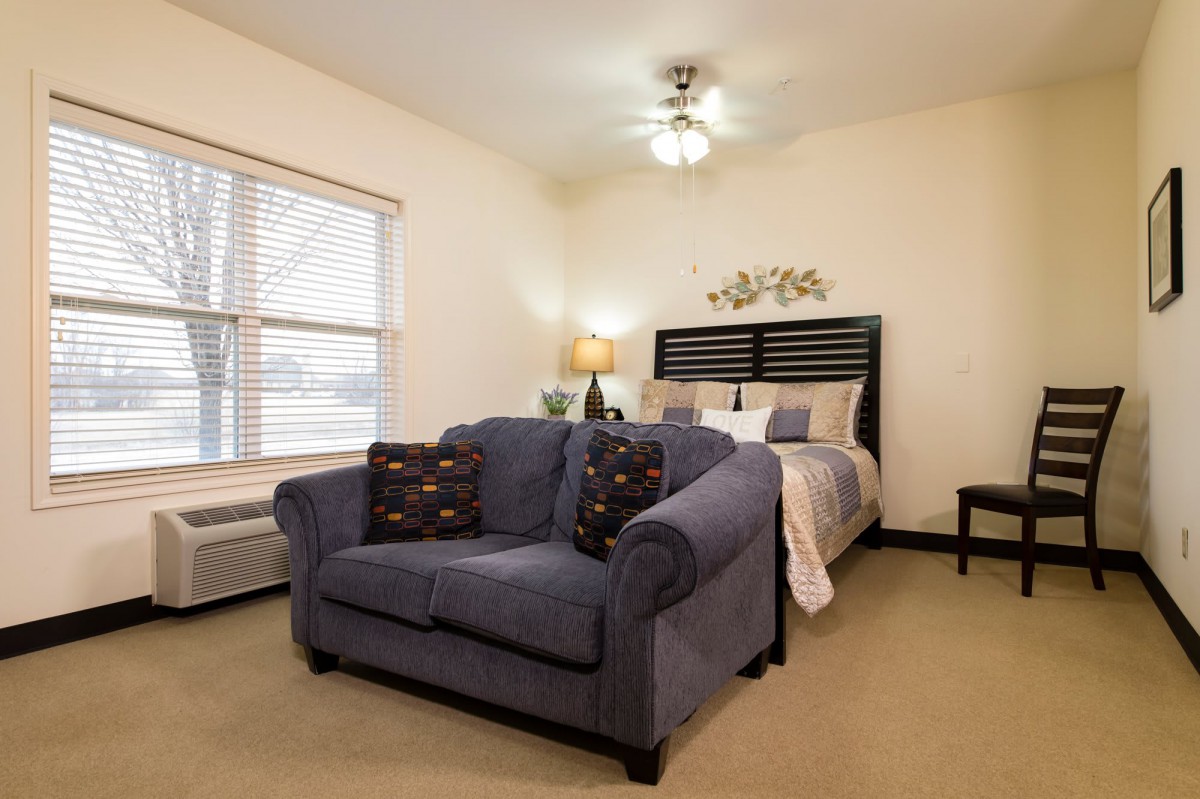 A cozy bedroom with a bed, couch, and stylish decor.