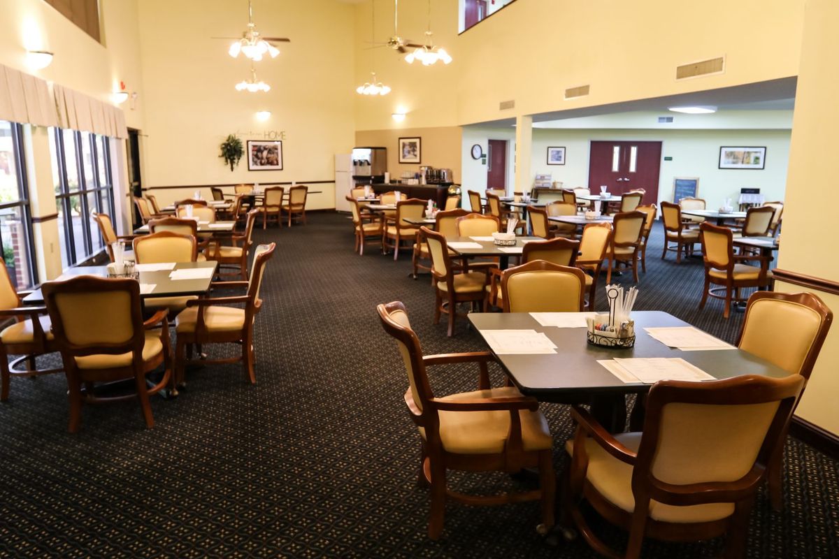An empty restaurant dining area with neatly arranged tables and chairs.
