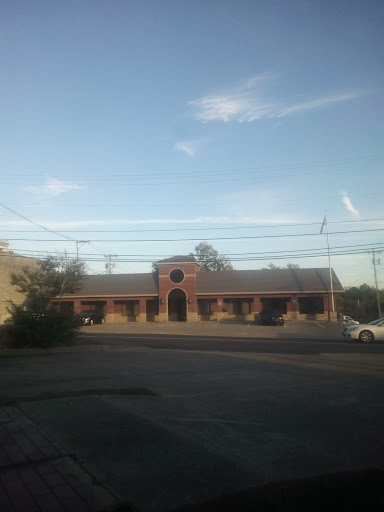 A view of a brick building with a clear sky and surrounding landscape.