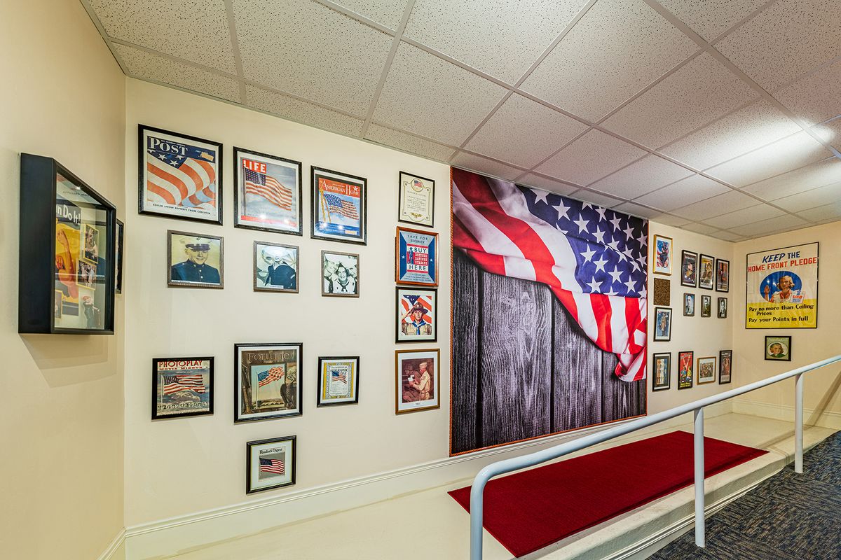 A hallway featuring a large American flag mural and framed posters on the wall in a patriotic display.