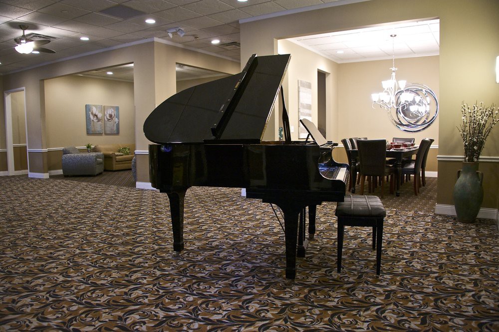 A grand piano situated in a well-furnished lounge area.
