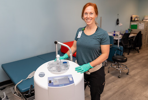 A healthcare professional stands beside medical equipment, ready to assist patients.