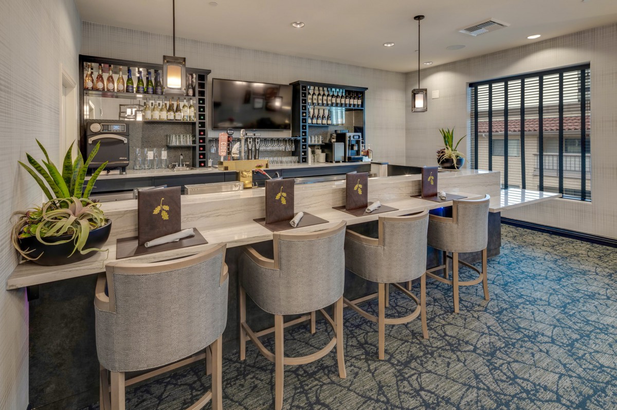 A modern bar interior with a sleek counter and comfortable seating.
