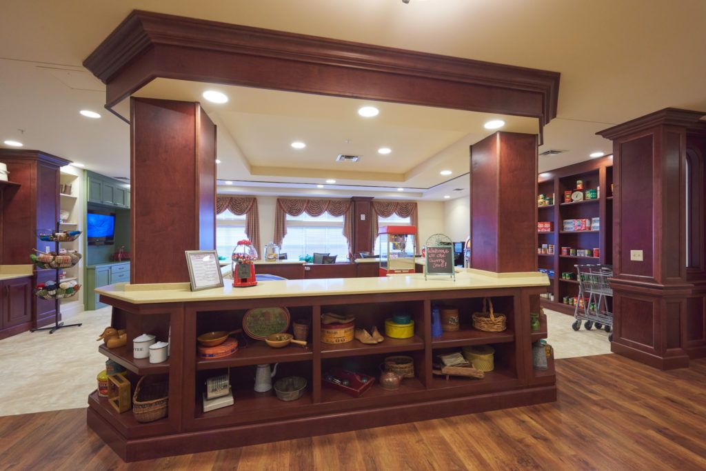 A cozy reception area featuring wooden furnishings and open shelves, warmly lit to create an inviting atmosphere.